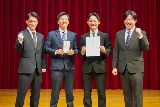 Ranchu Japan創価大学SDGsグッドプラクティス最優秀賞受賞写真、代表大束良明が賞状を持ち、桑原翔太が賞金を持っている、磯部祐亮、荻野匠と4名での記念写真