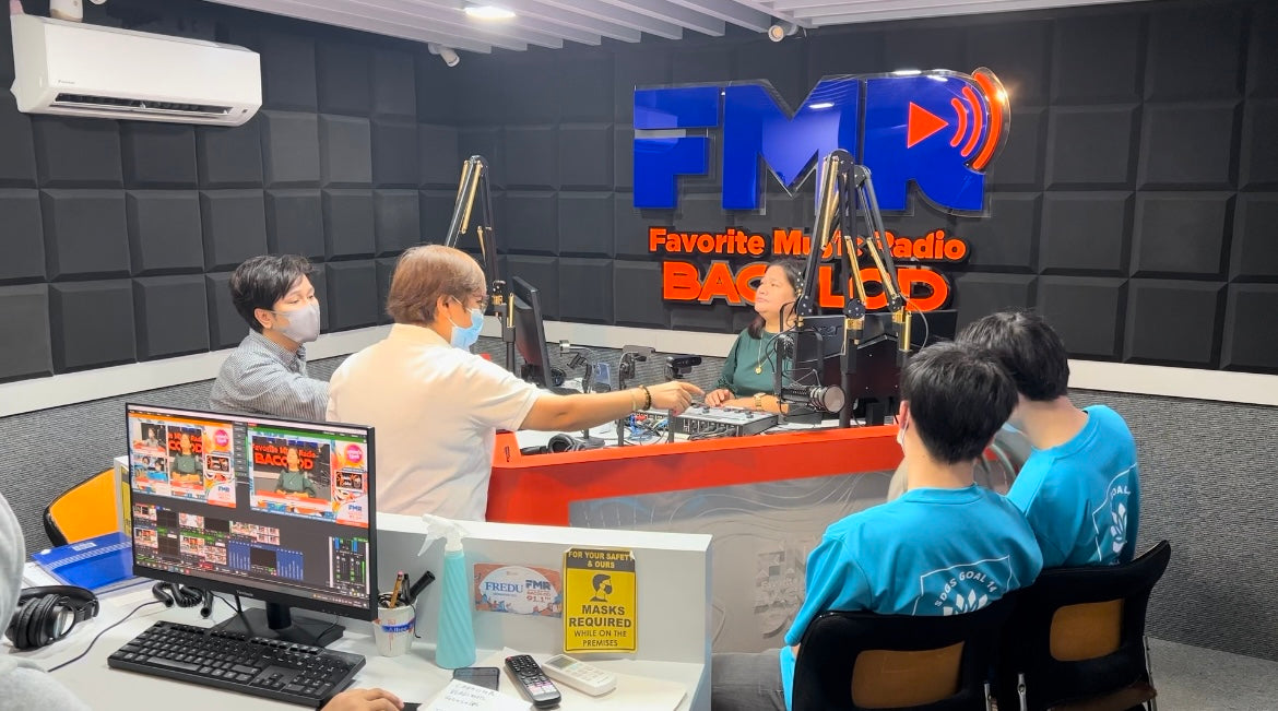 Ranchu Japan合同会社代表大束良明と通訳桑原翔太がフィリピンのFMRラジオスタジオで海洋ごみ解決について話している俯瞰写真