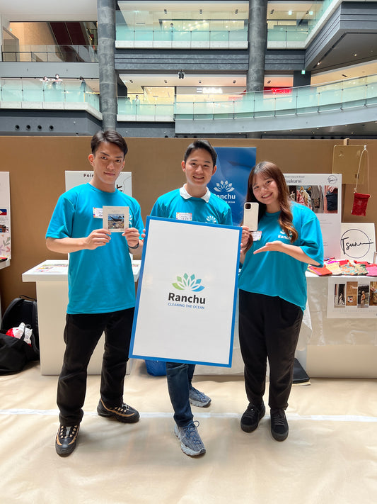エシカルエキスポ2023終了後、Ranchu Japan代表大束良明とスタッフ3名が展示スペース前で記念写真。大束良明がロゴ入りパネルを持っている。